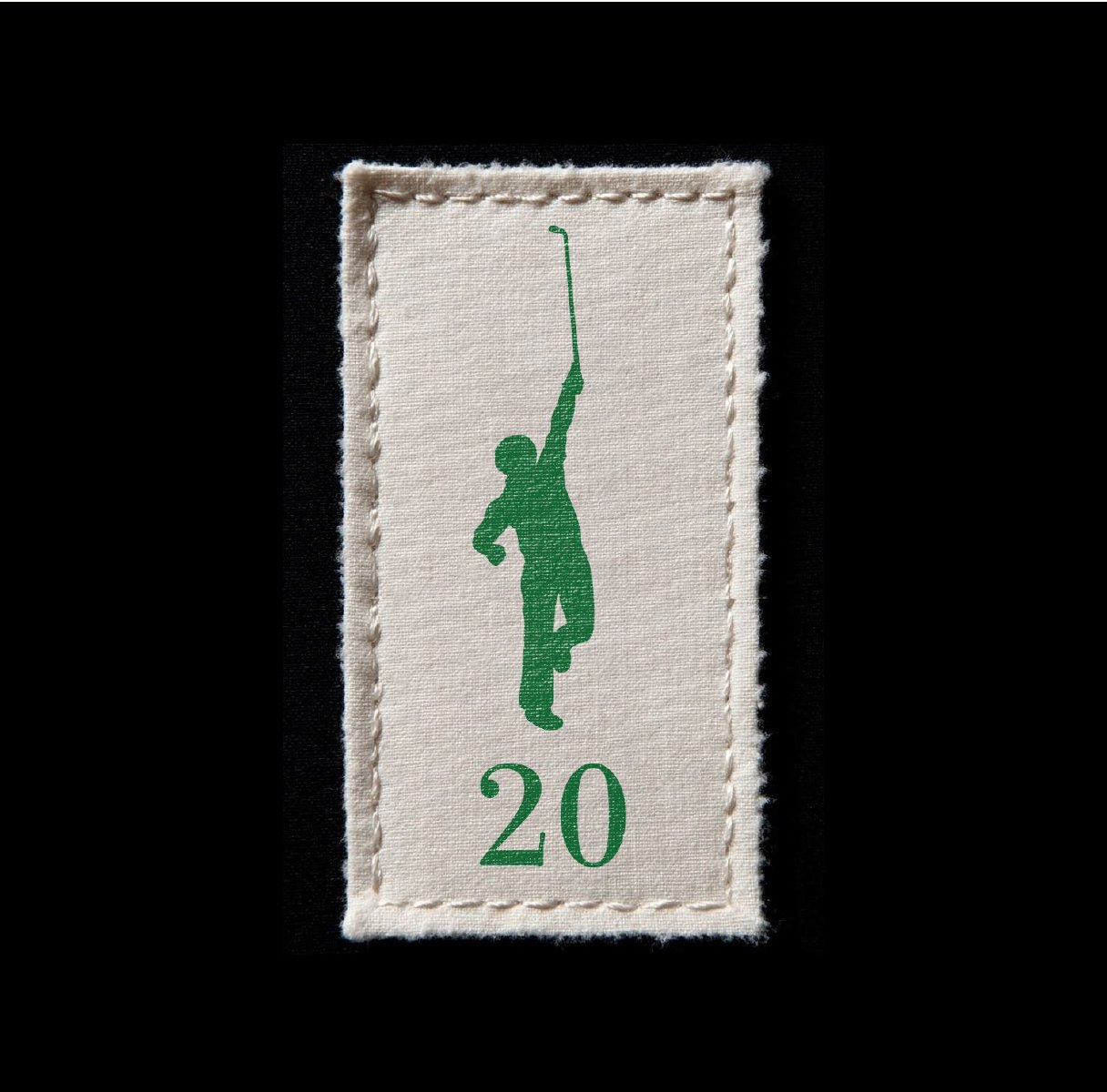 A small woven cream label carrying the green golfer silhouette above the numeral 20.