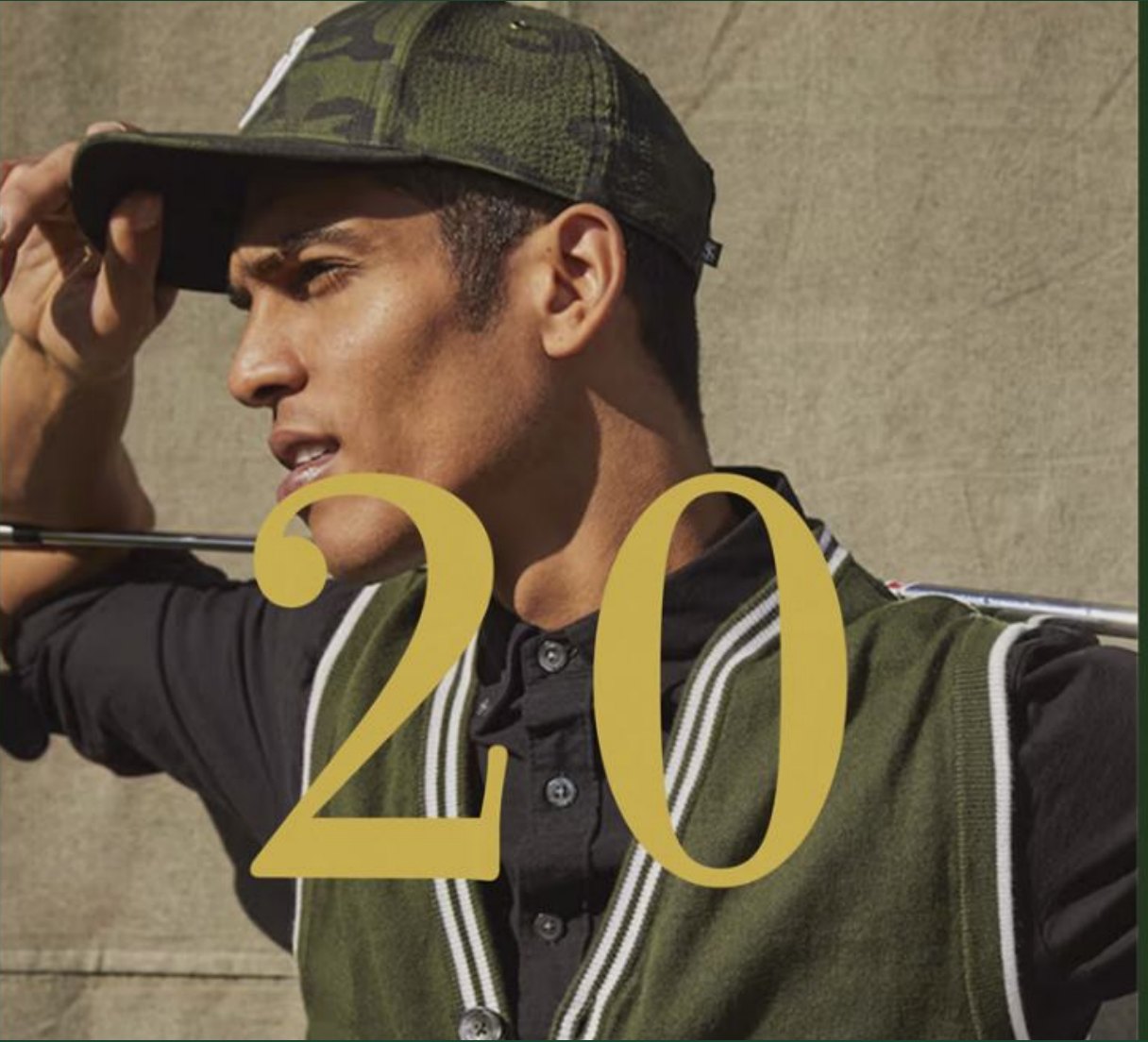 Contemporary model in an olive layered piece with the gold numeral 20 overlaid.