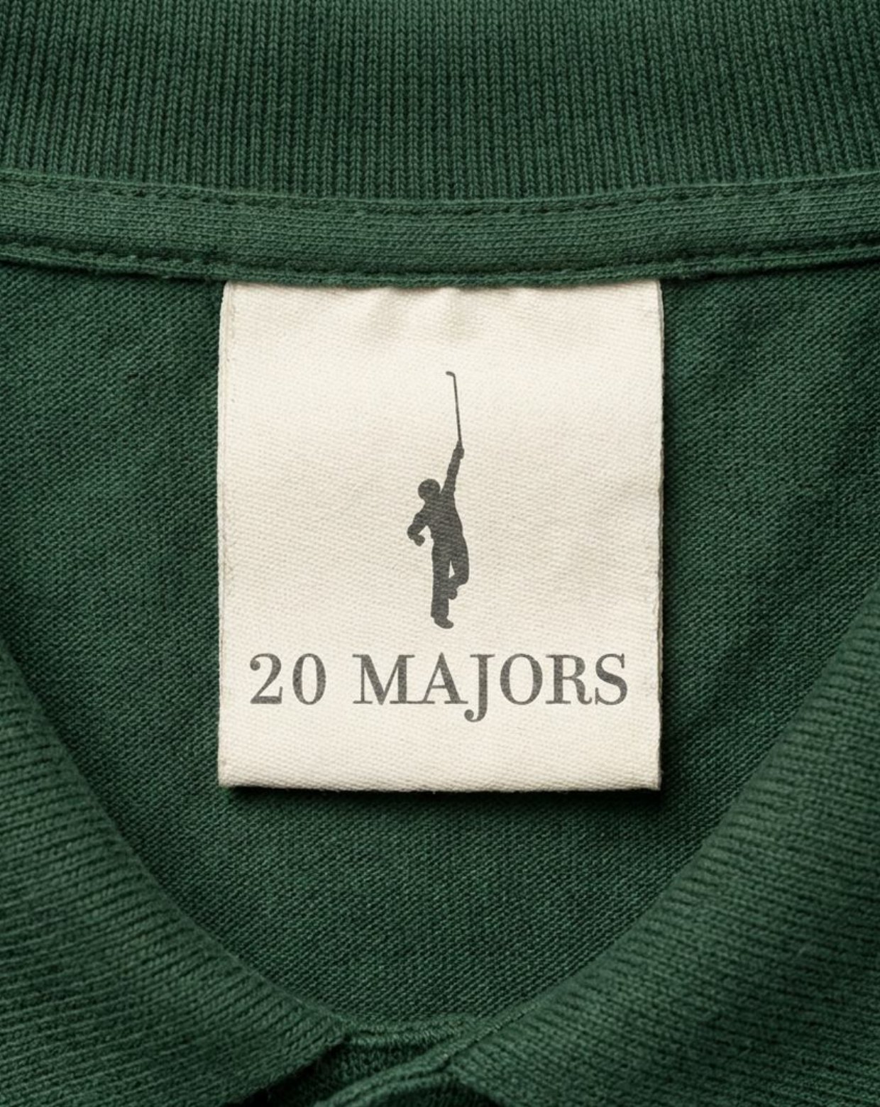 A cream woven 20 Majors label stitched inside the collar of a green knit.
